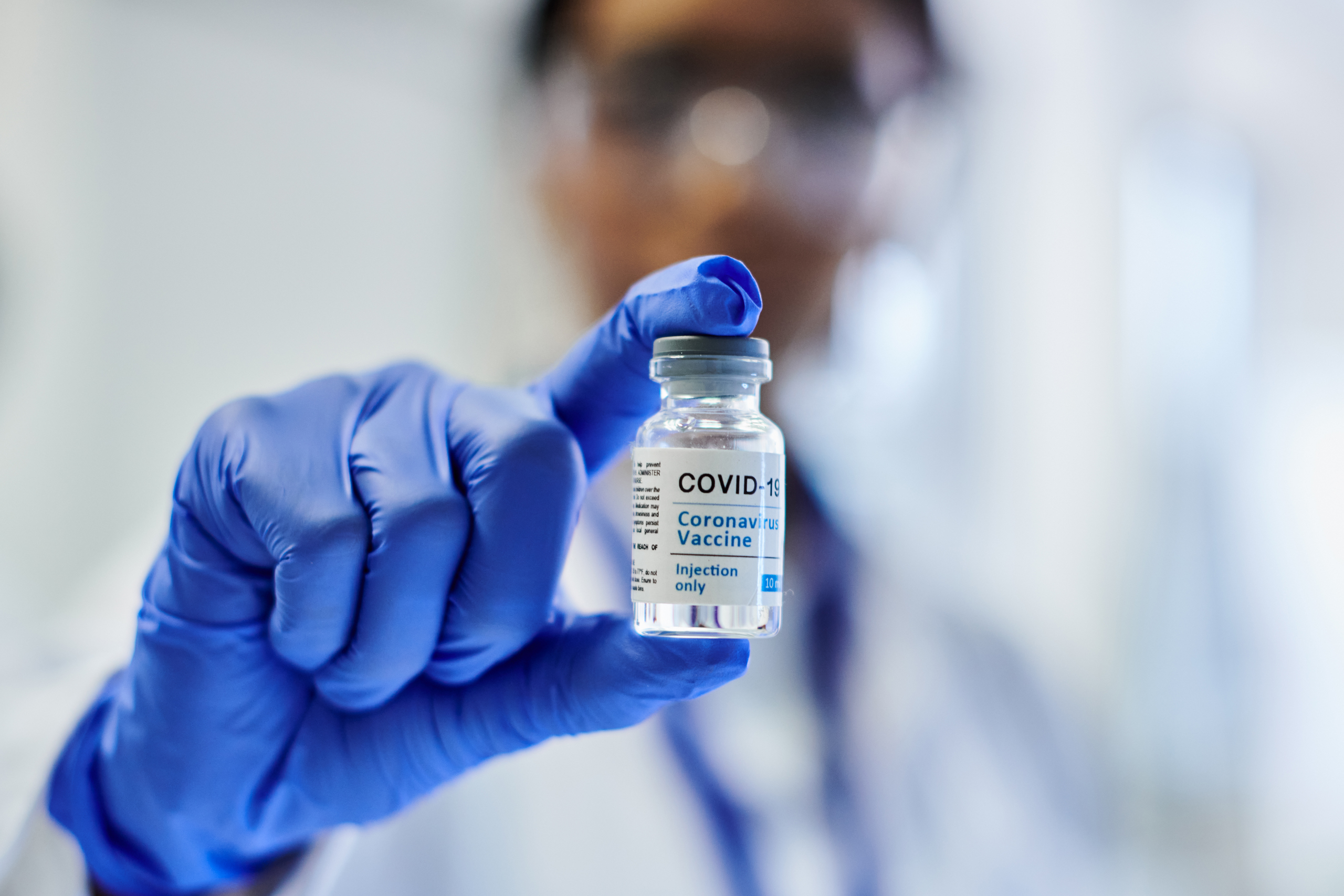 Medical professional holds bottle of containing medicine.